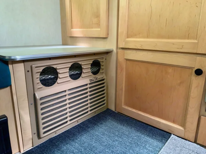 Compact RV rental interior featuring a built-in Cool Cat heat pump unit, wood cabinetry, and a countertop.. T@B T16 2008