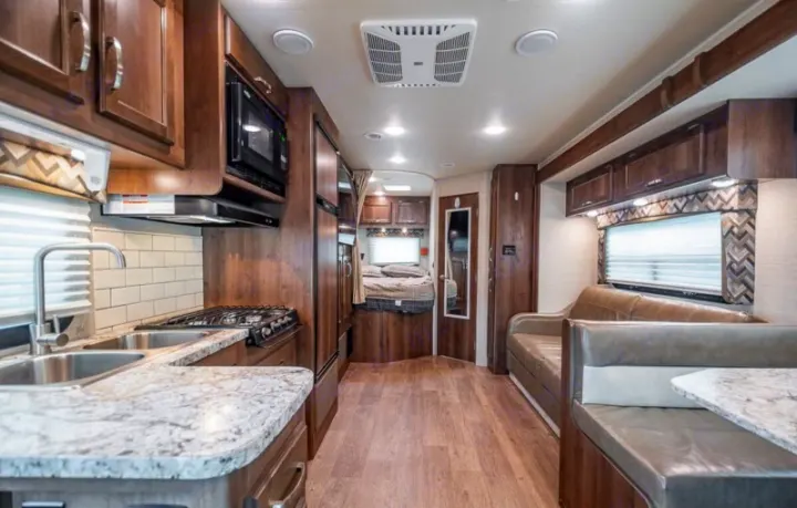 Spacious RV rental interior: full kitchen, dinette, sofa, and cozy bedroom. Ideal for road trips & adventures.. Jayco Redhawk 2018