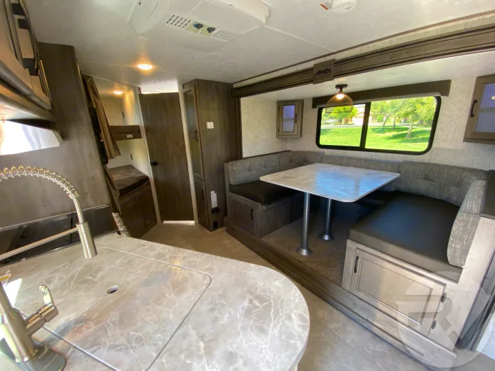 Explore this spacious RV rental interior with a modern kitchen, U-shaped dinette, and convenient bunk beds.. Coachmen Apex 2021