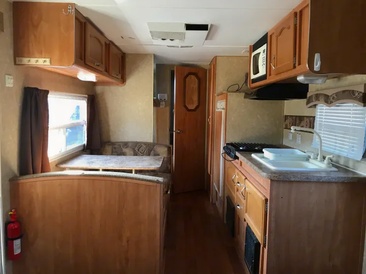 Spacious RV rental interior featuring a full kitchen, dinette, and ample storage. Perfect for your next road trip adventure.. Gulf Stream Ameri-Lite 25 BS 2008