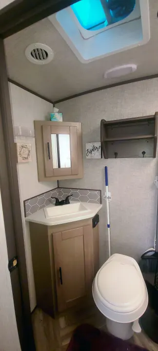A practical RV rental bathroom: compact with a sink, toilet, overhead vent, and storage. Ready for your travels.. Cruiser Rv Corp Shadow Cruiser 2020