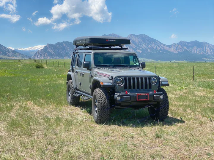 Grey Jeep Wrangler with roof-top tent, perfect for an rv rental and exploring scenic mountain landscapes.. Jeep Wrangler Unlimited 2021