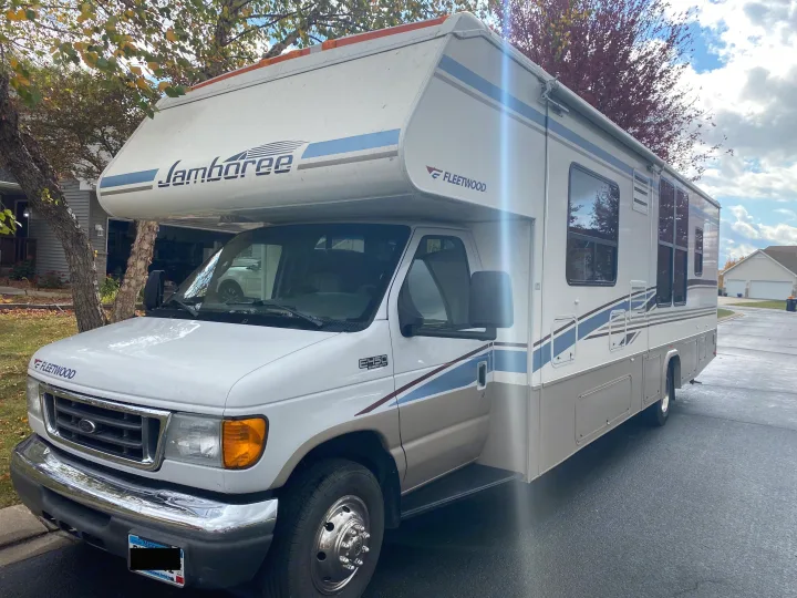 A white & tan Fleetwood Jamboree Class C RV, featuring blue stripes & a Ford E-450 front, ideal for rv rental.. Fleetwood Jamboree 2005