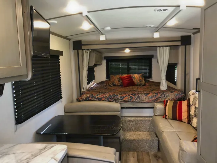 This rv rental offers a cozy bedroom, versatile dinette, & comfortable living area with TV.. Keystone Outback Ultra-Lite 2021