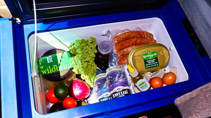 Inside an RV rental's portable fridge: Packed with essentials like sausages, Kerrygold butter, eggs, veggies, and Jenny Lake beer for camping trips.. Chevrolet Other 2003
