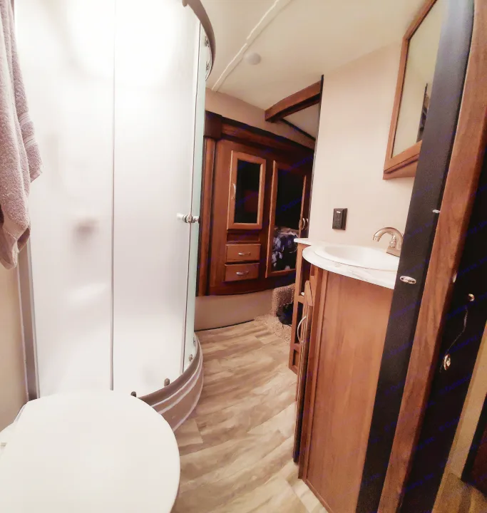 Compact RV rental bathroom with a frosted shower, toilet, and vanity sink.. Forest River Coachmen Chaparral Lite 2020
