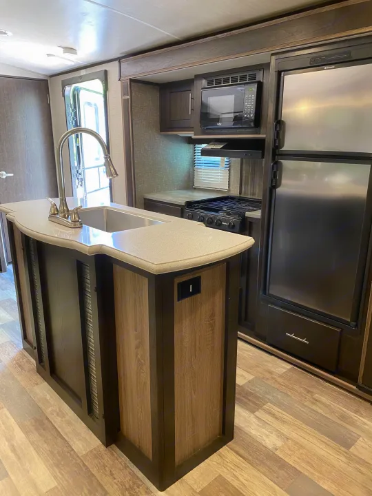 Rv rental: Modern kitchen with island sink, built-in microwave, stove, and stainless steel refrigerator.. Other Fun Finder 2017