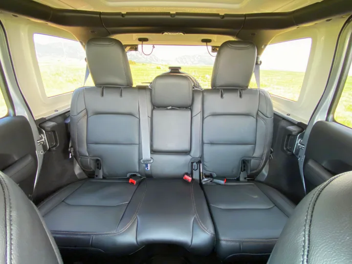 Comfortable rear black leather seats in your rv rental adventure vehicle, offering scenic mountain views.. Jeep Wrangler Unlimited Rubicon 392 2021