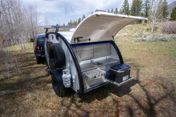 This RV rental's teardrop camper features an open rear galley kitchen with a sink, stove, and cooler for outdoor camping.. Bean Trailer Mean Bean 2021