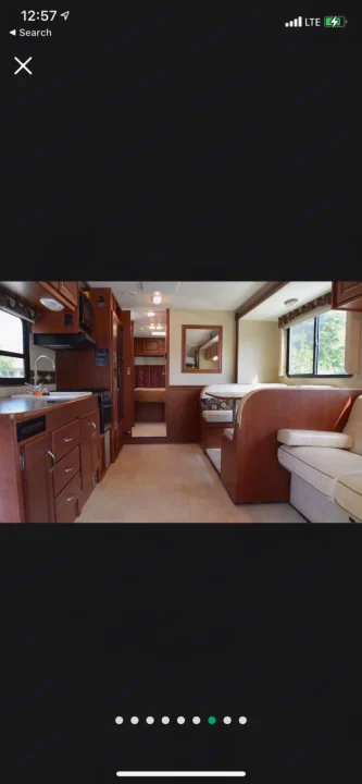 Bright RV rental interior: kitchen with wood cabinets, U-shaped dinette, and a comfortable sofa.. Winnebago Minnie Winnie 2015
