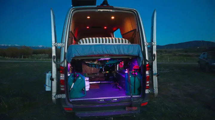 RV rental's spacious interior: bed above gear storage, illuminated for nightly comfort in the wilderness.. Mercedes-Benz Sprinter 2016