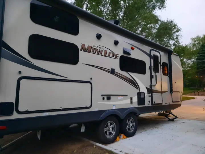 This Rockwood Mini Lite travel trailer, an RV rental, is parked at a campsite, ready for your next adventure.. Forest River Rockwood Mini Lite 2021