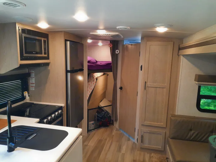 Inside an rv rental: functional kitchen, cozy bunk beds, and a comfortable dinette. Ready for your next trip.. Forest River Rockwood Mini Lite 2021