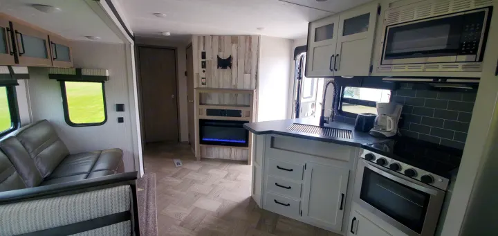 Modern RV rental interior with a cozy living area, full kitchen, and fireplace. Perfect for travel adventures.. Palomino Puma 2021