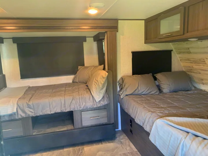 Here you can see the dinette slide out converted into a full size bed, as well as the queen sized bed at the front of the trailer.. Dutchmen Kodiak 2021