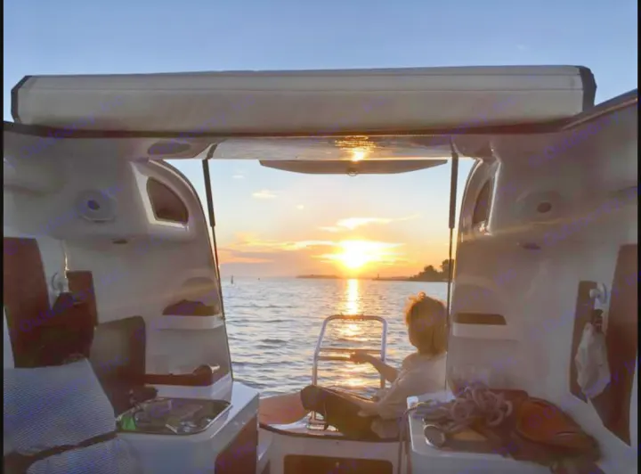 A person on a boat watches a stunning sunset from inside the cabin. Enjoy this freedom, akin to an RV rental adventure!. Sealander Sealander 2021