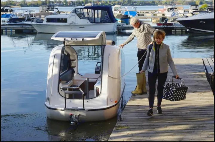 Enjoy a unique 'RV rental' experience on water! A couple embarks on a compact cabin boat from a dock, perfect for lake adventures.. Sealander Sealander 2021