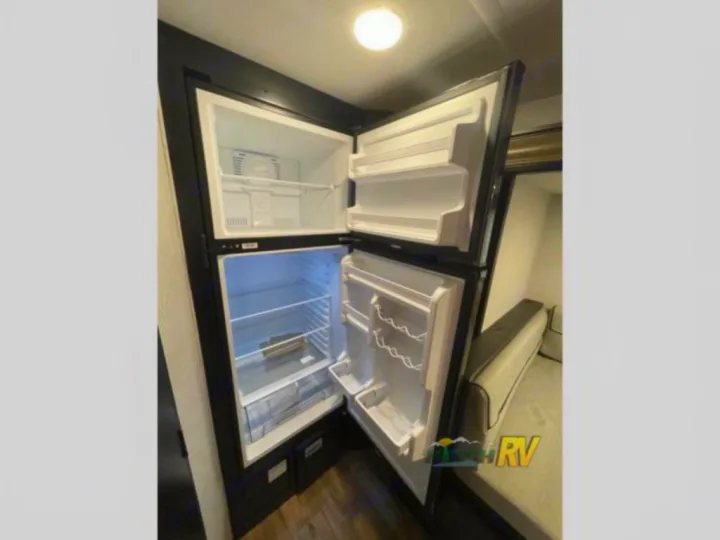 This RV rental features a clean, spacious two-door refrigerator and freezer, perfect for your travels.. Forest River Cherokee Wolf Pup 16PFBL 2021