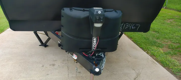 Black RV rental: Front hitch of a travel trailer with electric jack, propane tanks, and safety chains on concrete.. Grand Design Transcend Xplor 2021