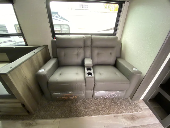 RV rental interior: Comfy gray two-seat recliners with cupholders (Thomas Payne Collection) for travel.. Sportsmen LE 2021