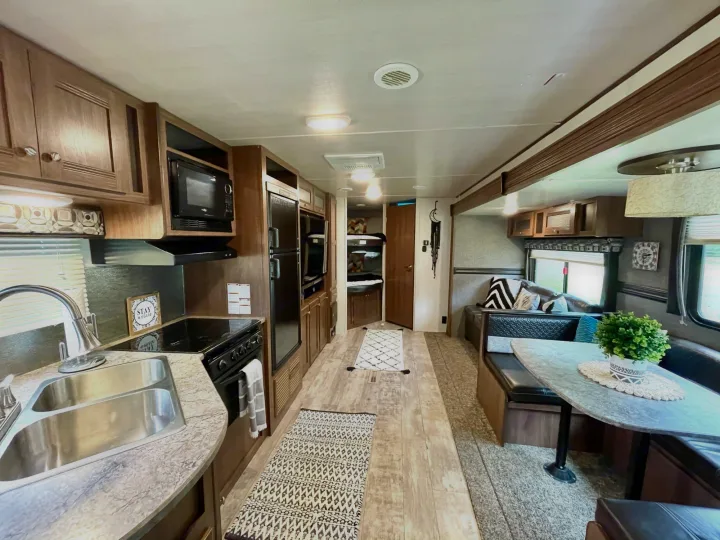 Modern RV rental interior: full kitchen, comfortable dinette, and bright living space.. Heartland Pioneer 2018