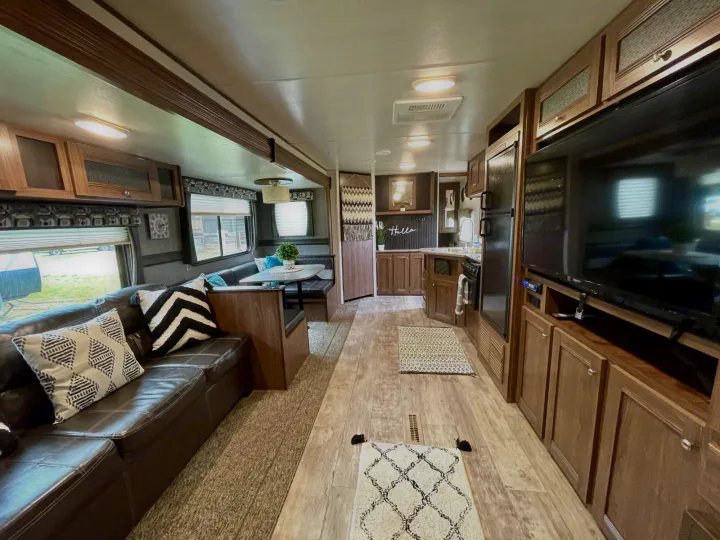 Spacious RV rental interior featuring a cozy living area, dining booth, and full kitchen, perfect for your next adventure.. Heartland Pioneer 2018