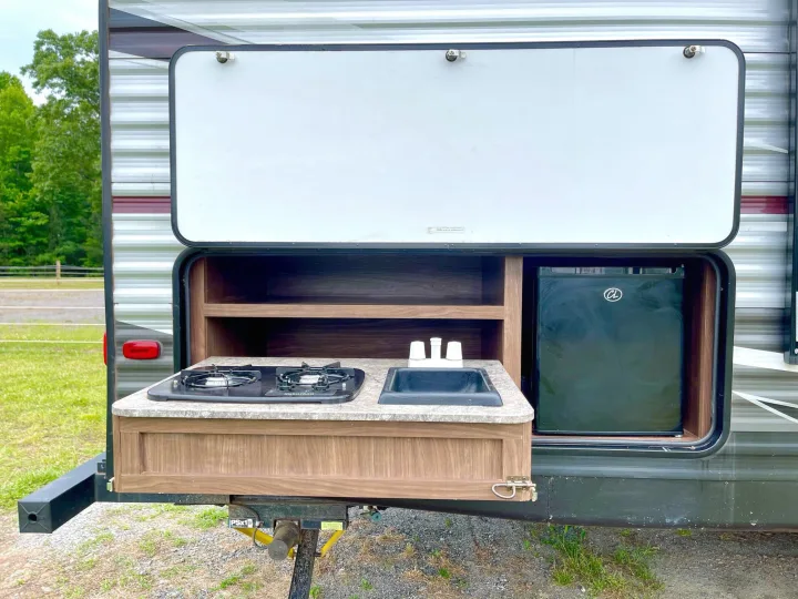 This RV rental features a convenient pull-out outdoor kitchen with a stovetop, sink, and mini-fridge.. Heartland Pioneer 2018