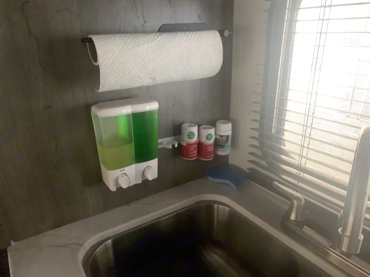 Compact RV rental kitchen with sink, paper towels, dual soap dispenser, spices, and window blinds.. Pioneer BH170 2021