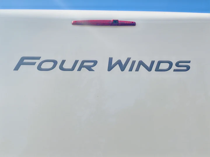 The rear of a white Four Winds RV, equipped with a backup camera and brand name. Great for an RV rental experience.. Thor Motor Coach Four Winds 2019