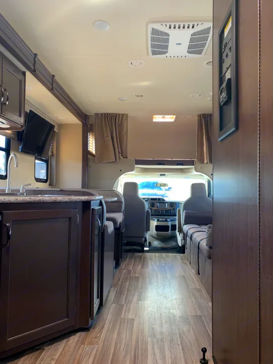 Interior of a modern rv rental, featuring a well-equipped kitchen, comfortable living area, and driver's cabin.. Thor Motor Coach Four Winds 2019
