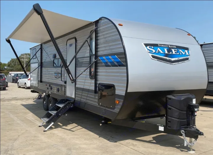 Spacious grey Forest River Salem travel trailer with an extended awning and steps. Ideal for an RV rental adventure.. Forest River Salem 2021