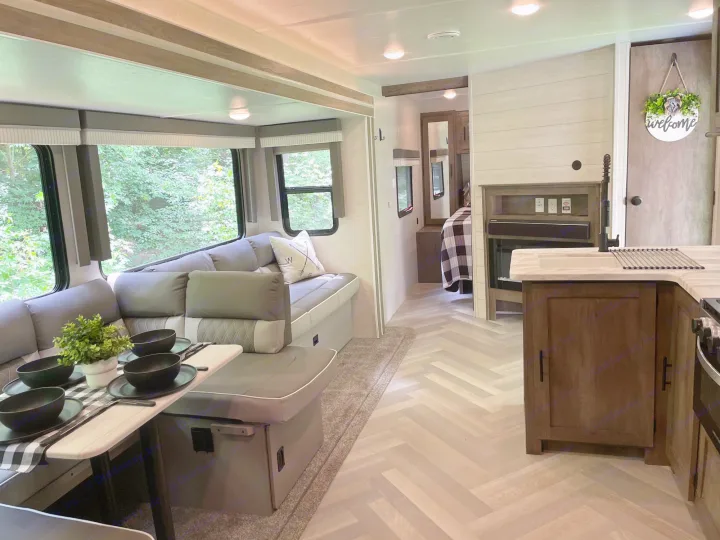 Cozy RV rental interior: spacious dinette, kitchen with fireplace, and bright living area. Perfect for travel.. Forest River Salem 2021
