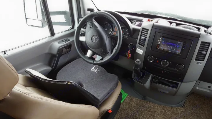 Inside an RV rental van: driver's seat, Mercedes steering wheel, & dashboard with infotainment system.. Mercedes Benz Four Winds 2018