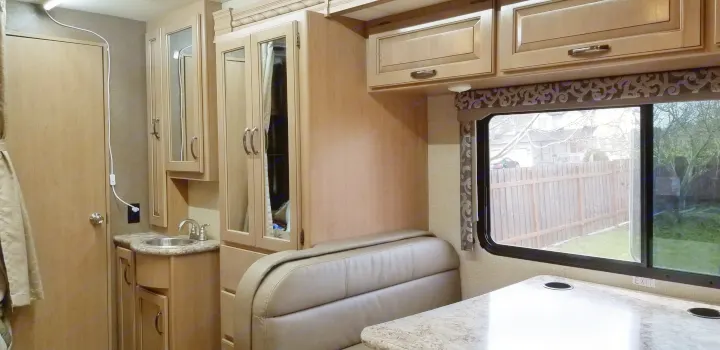 This RV rental interior showcases a compact kitchen, dinette seating, and smart storage in light wood finishes.. Mercedes Benz Four Winds 2018