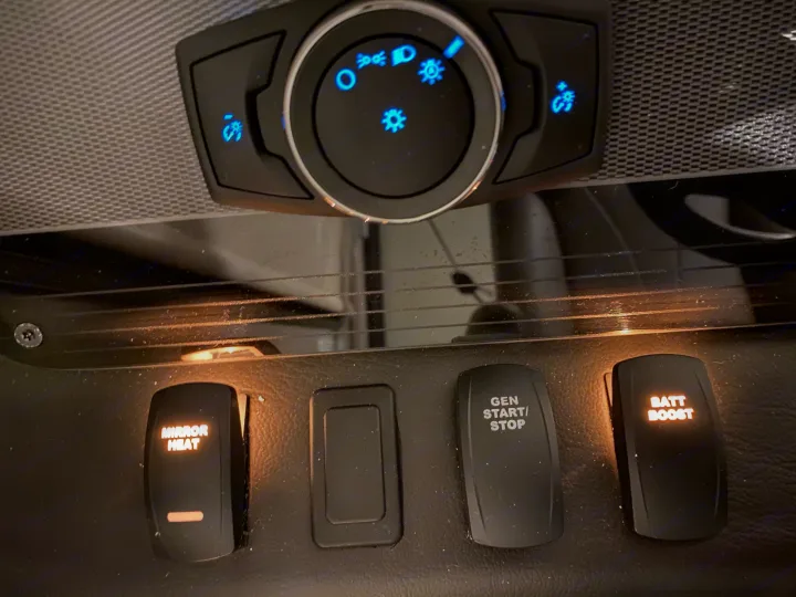 RV rental interior view: Illuminated controls for mirror heat, generator, battery boost, and vehicle lighting.. Jayco Alante 2021