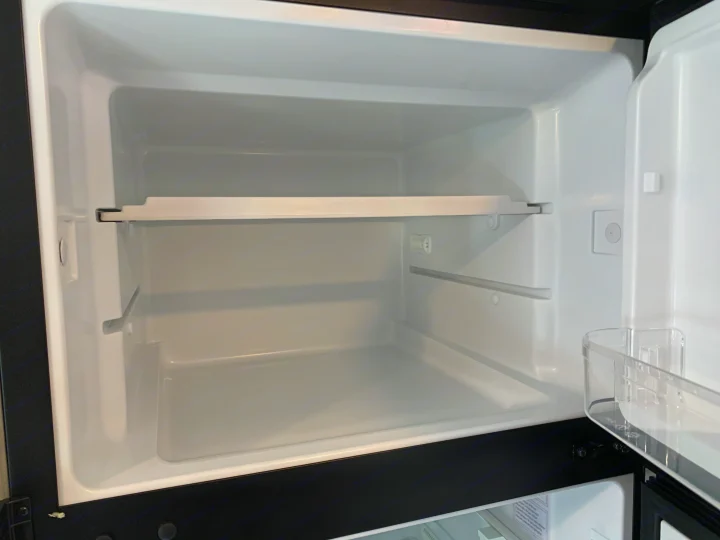 Clean, empty refrigerator interior for an RV rental. Features shelves and door storage.. Coachmen Freelander 2022