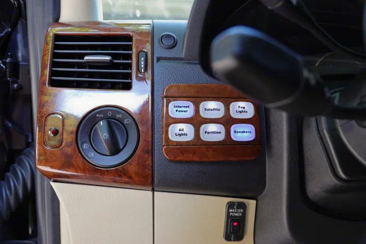 An RV rental's custom interior dashboard, featuring wood-grain trim and advanced controls for internet, satellite, lighting, and more.. Mercedes 3500 2018