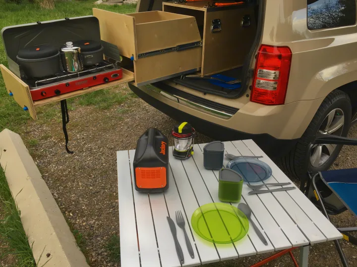 RV rental alternative: SUV with custom pull-out camping kitchen, stove, Jackery power, and portable dining setup.. Jeep Patriot 2016