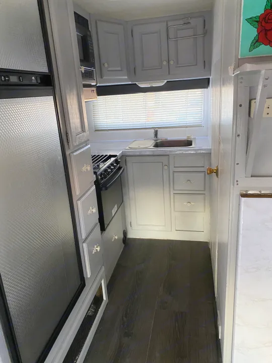 Modern RV rental kitchen with gray cabinets, dark floors, and full appliances.. Holiday Rambler Atlantis 2002