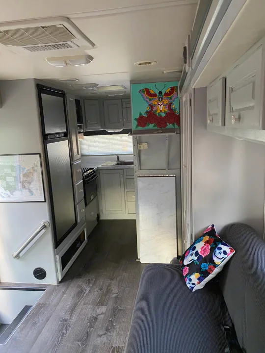 RV rental interior: A modern gray kitchen, full-size fridge, and cozy living space with a vibrant skull pillow.. Holiday Rambler Atlantis 2002