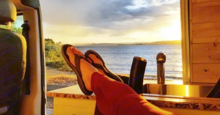 Relaxing RV rental view: feet up, lake sunset, and golden skies. Perfect van life moment.. Dodge Ram Promaster 2500 2019