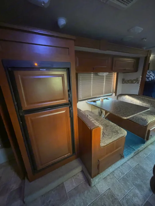 Spacious RV rental interior with a Dometic fridge, comfy dinette, and overhead cabinets for convenient travels.. Other Other 2010