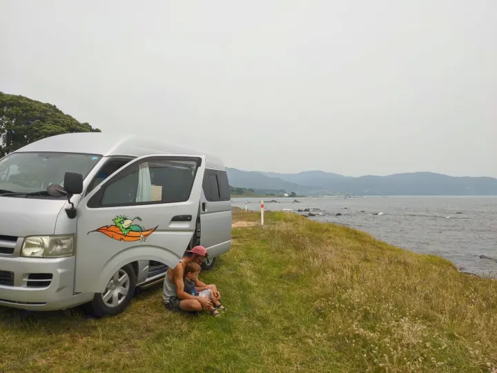 Relaxing family travel in an RV rental. A campervan parked by scenic waterfront offers a tranquil escape.. Toyota Hiace 2006