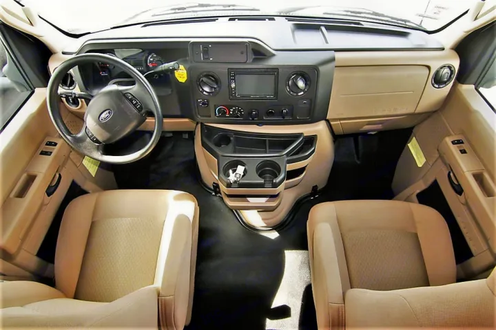 Spacious RV rental cockpit interior featuring steering wheel, dashboard with central console, and comfortable front seats.. Winnebago Outlook 2019