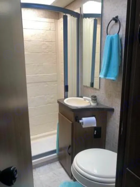 Compact RV rental bathroom featuring a shower, sink, and toilet, optimized for travel convenience and space.. Coachmen Freelander 2018