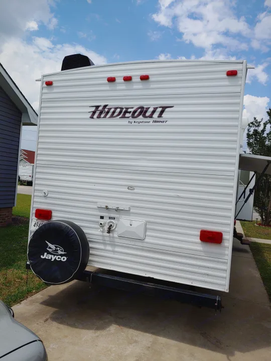 Back of a "Hideout" travel trailer with Jayco spare tire and utility hookups, ready for your RV rental adventure.. Keystone RV Hideout 2014