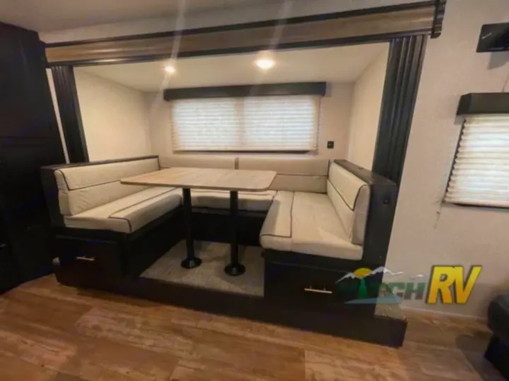 Spacious RV rental dinette with U-shaped booth seating and table. Perfect for meals in your travel trailer.. Forest River Cherokee Wolf Pup 16PFBL 2021