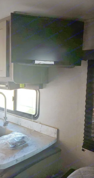 Inside an RV rental: Compact kitchen with marble-look counter, sink, window, and wall-mounted TV. Perfect for road trips.. Keystone Outback 2020