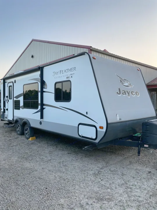 White & grey Jayco travel trailer on gravel. Great rv rental option for your next road trip adventure.. Jayco Jay Feather Ultra Lite 2015