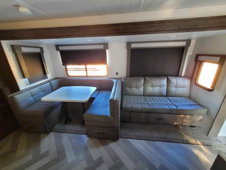 Comfortable RV rental interior featuring a spacious dinette, sofa, and modern amenities for your next adventure.. Forest River Salem 2021